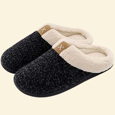Charcoal memory foam slippers with cream sherpa lining and black sole on beige background